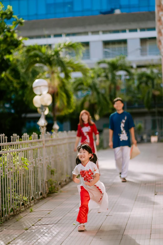 two s and an adult are walking on a sidewalk