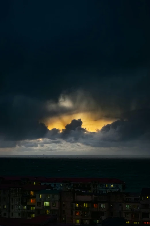 a night scene with the sun shining through dark clouds