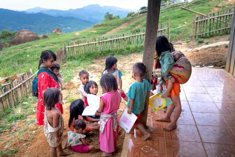 small children standing outside by a small wooden structure