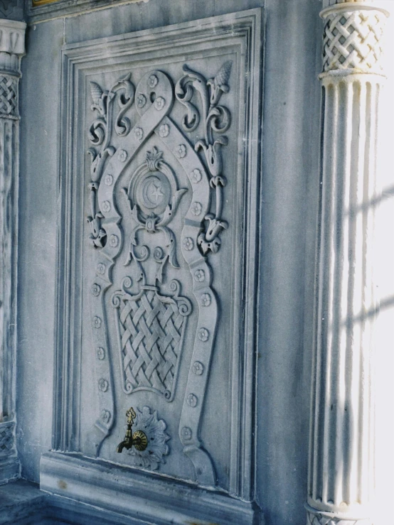 ornate architectural panelling adorns a wall in a room with blue paint and columns