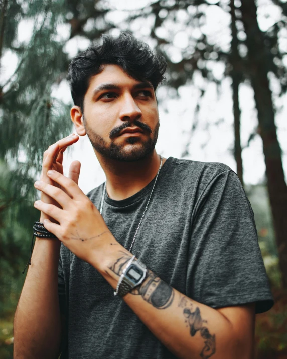 a man with a finger tattoo holding a cigarette