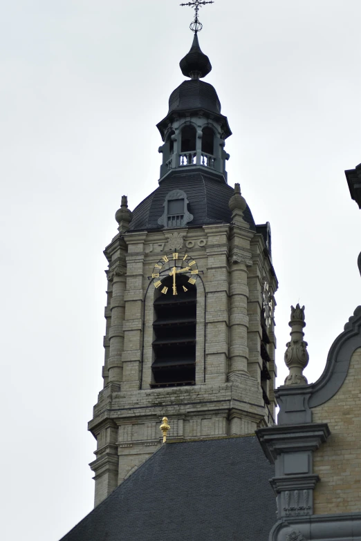 a church spire with a gold clock on it