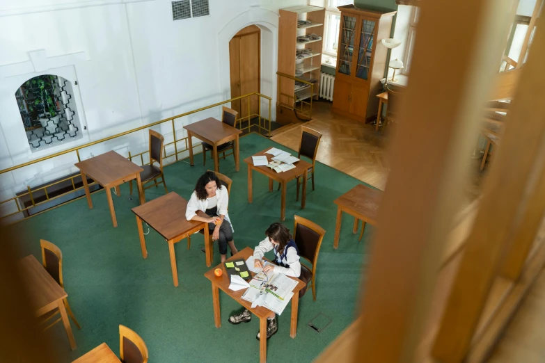 two women in a school classroom setting sitting at desks