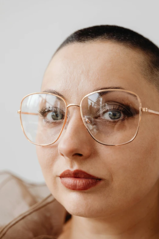 a woman wearing glasses, looking up to the camera