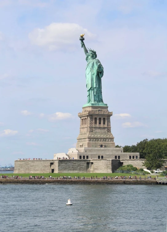 there is a boat that is floating on the water next to the statue of liberty