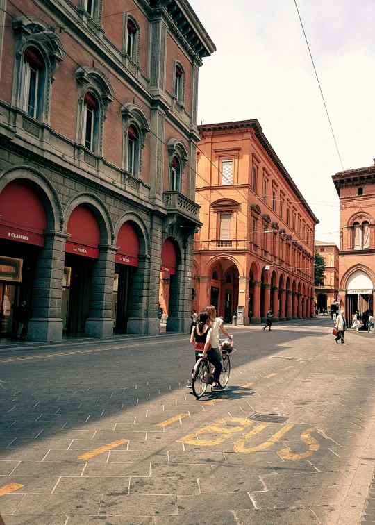 a man riding his motorcycle down a street in the middle of town