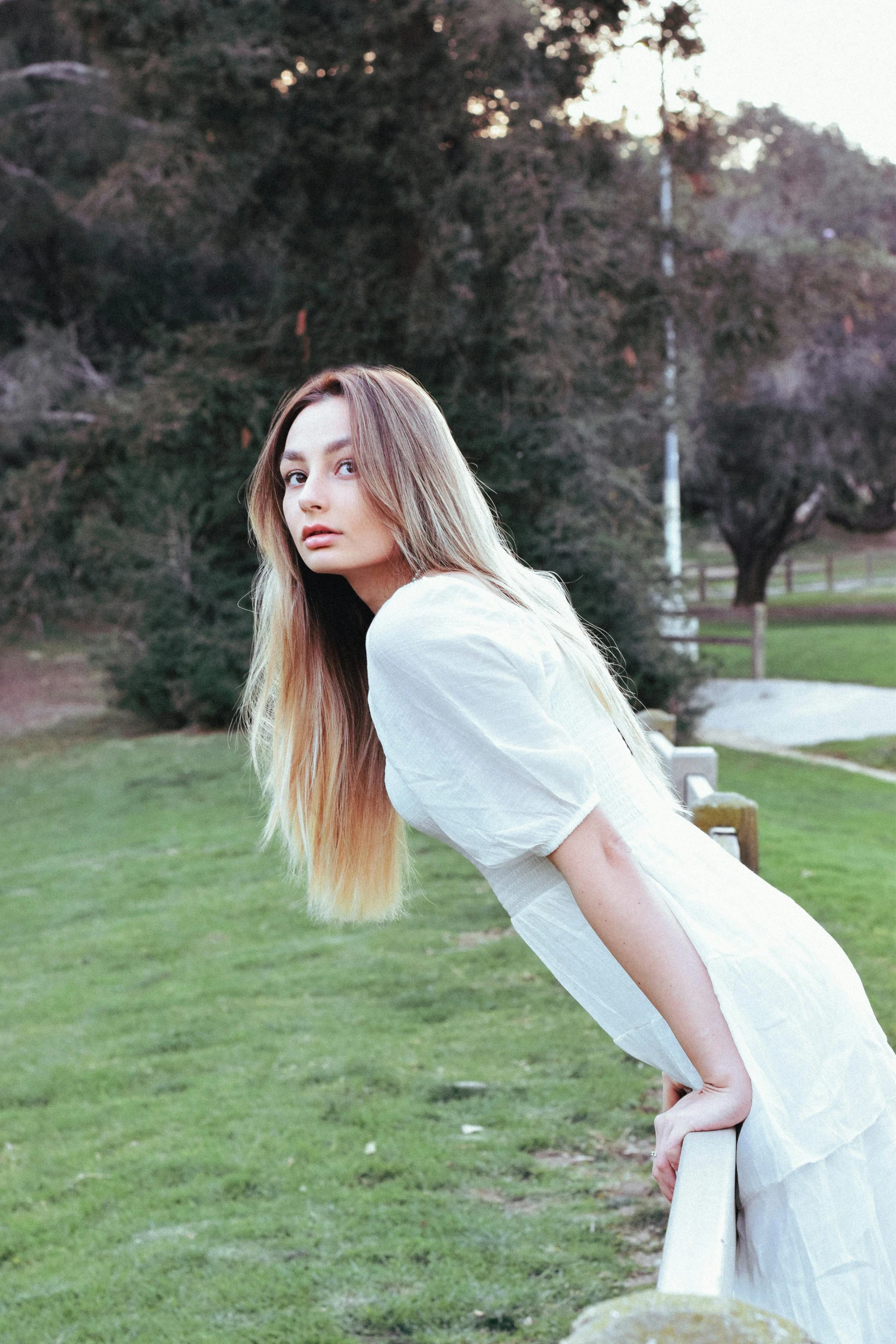 a woman with long hair standing next to a wall