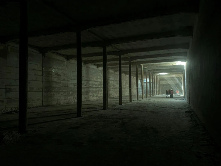 two people stand under the light at the end of a dark tunnel