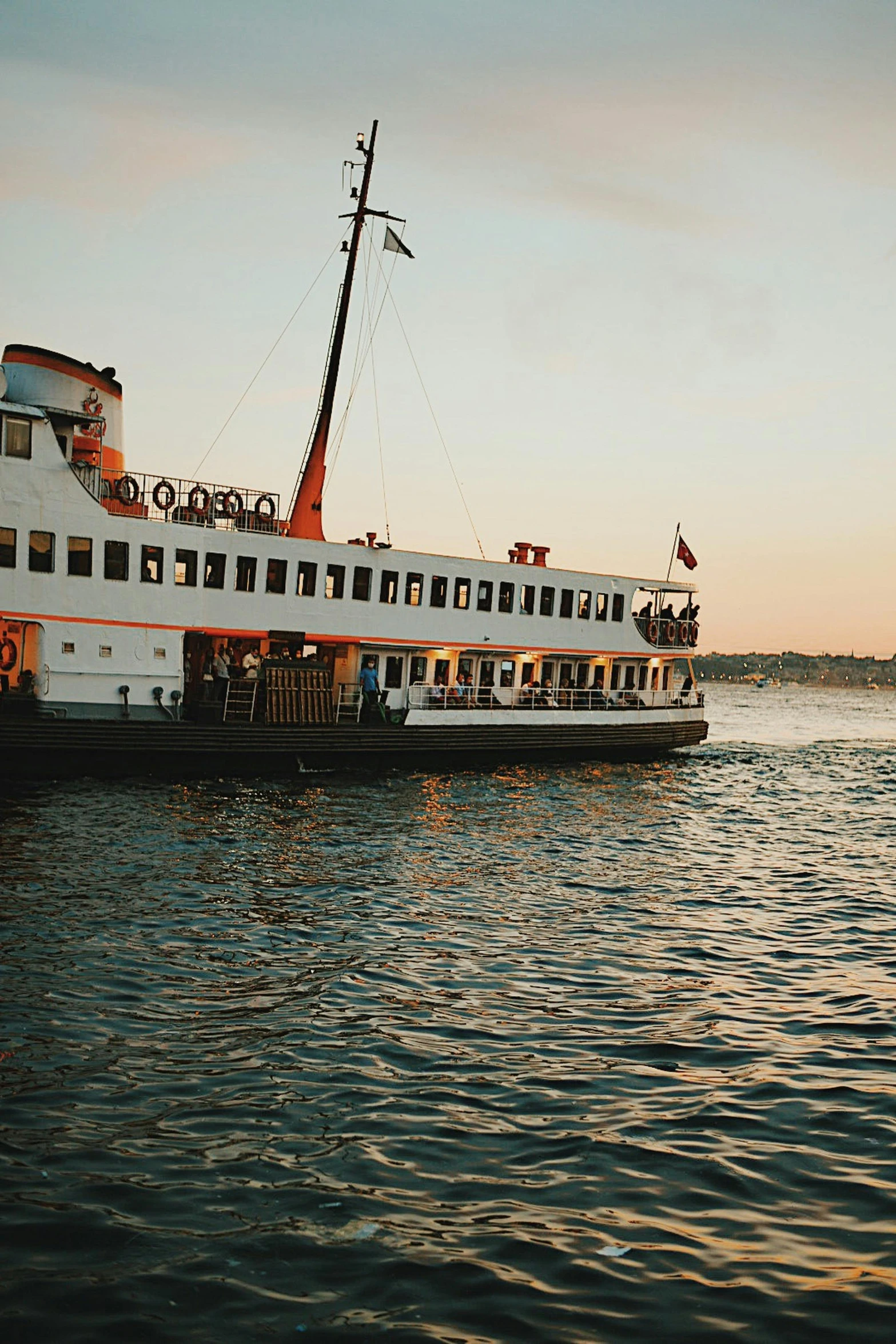 large boat floating down a body of water at sunset