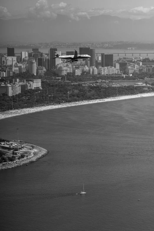 an airplane is flying over the ocean and a city