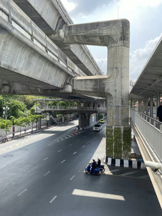 people ride motorcycles down an urban street