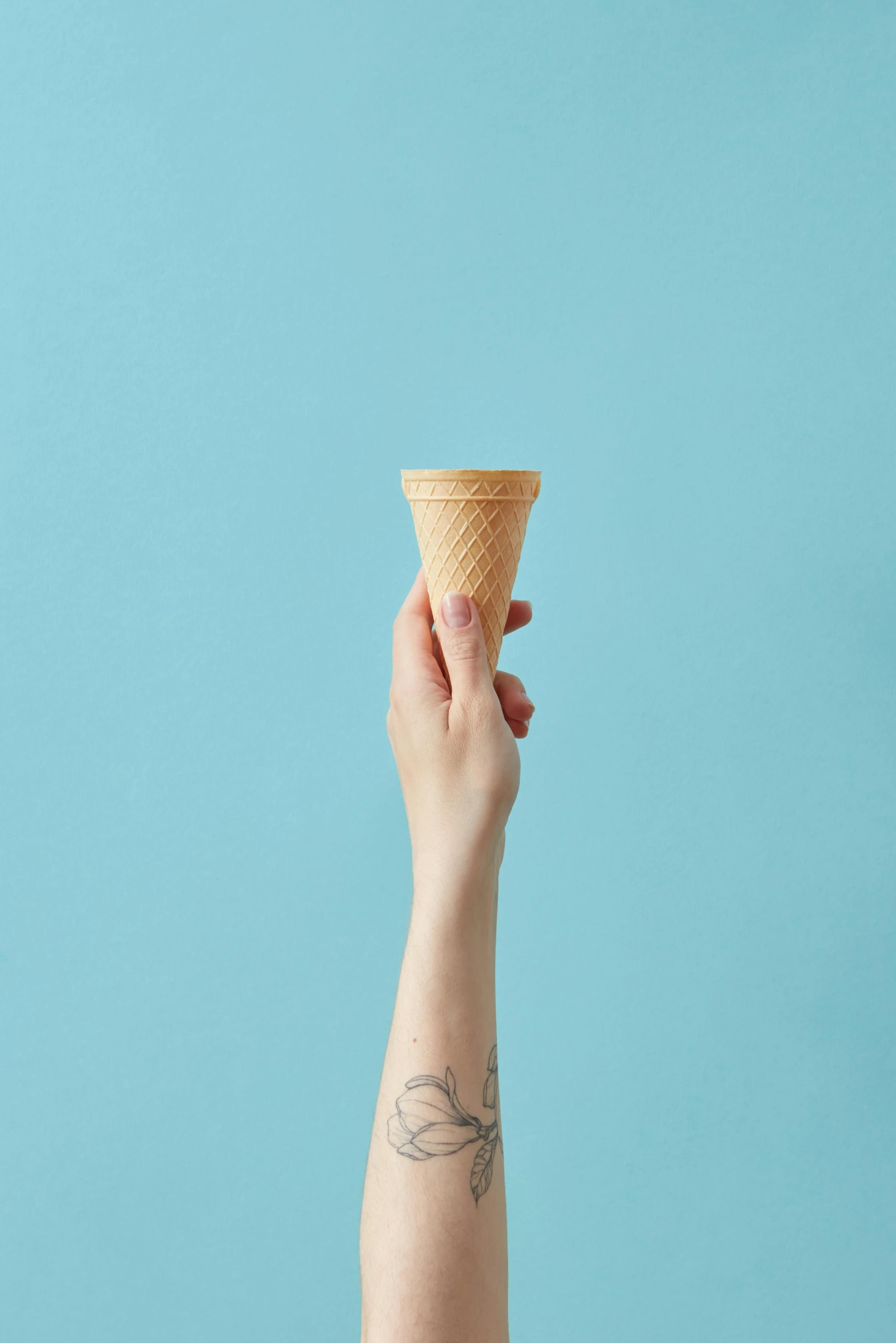 a woman's hand holding an ice cream cone