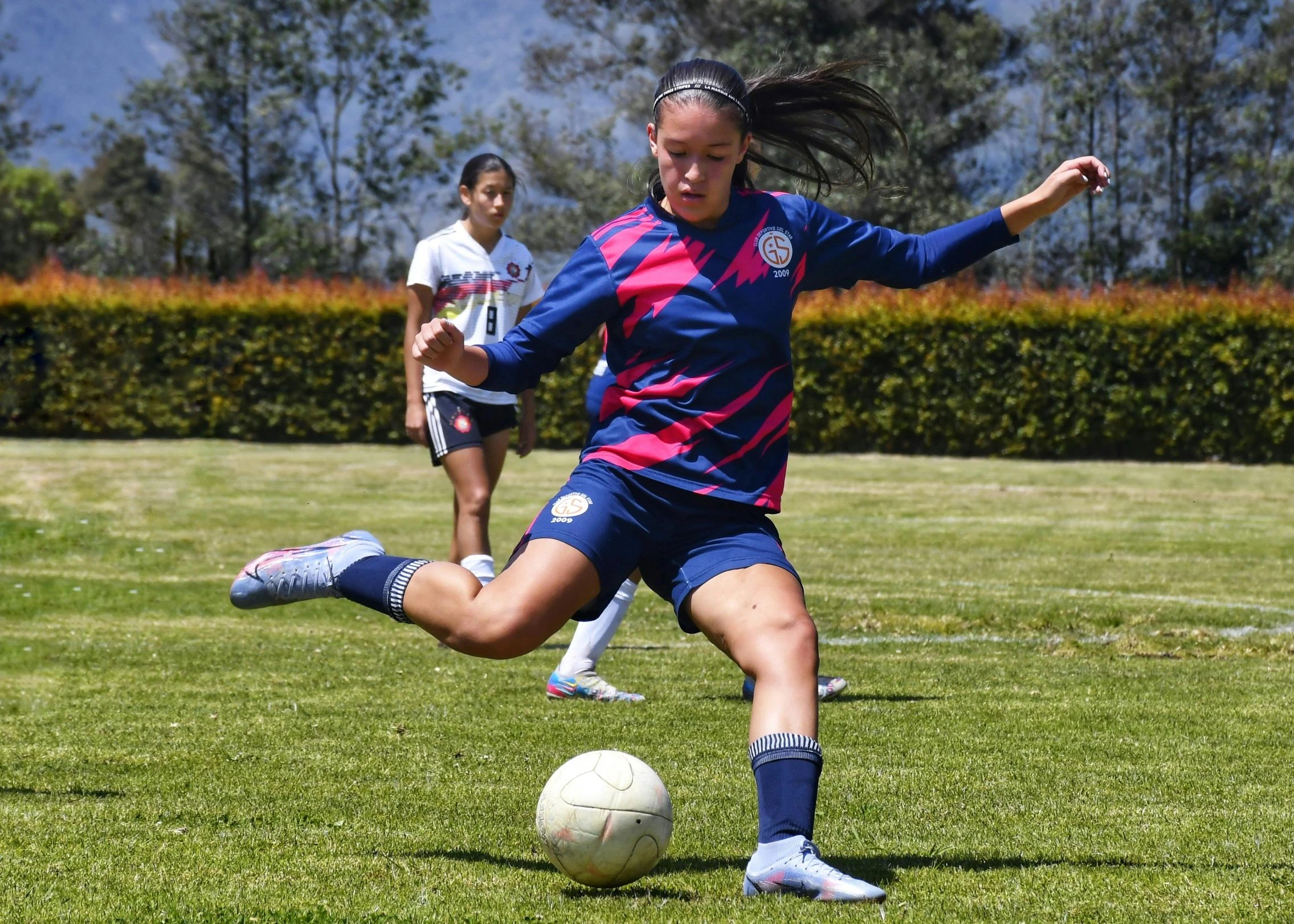 two s are playing soccer together in a field