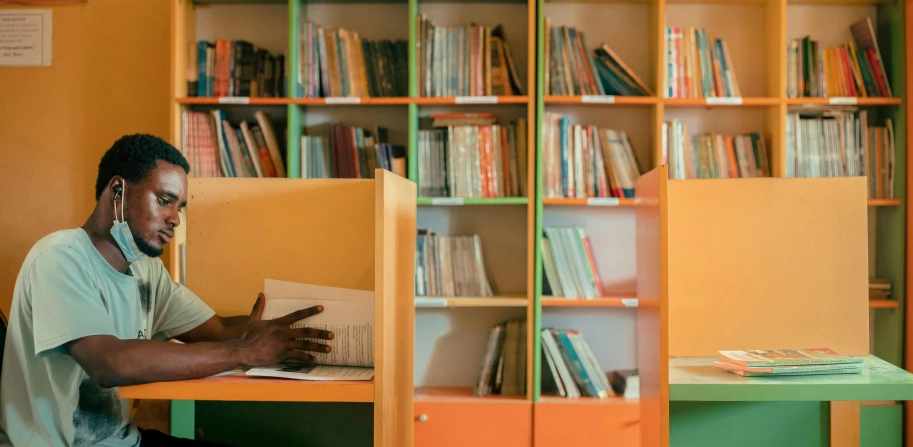 a man sitting at a table with a book in front of him