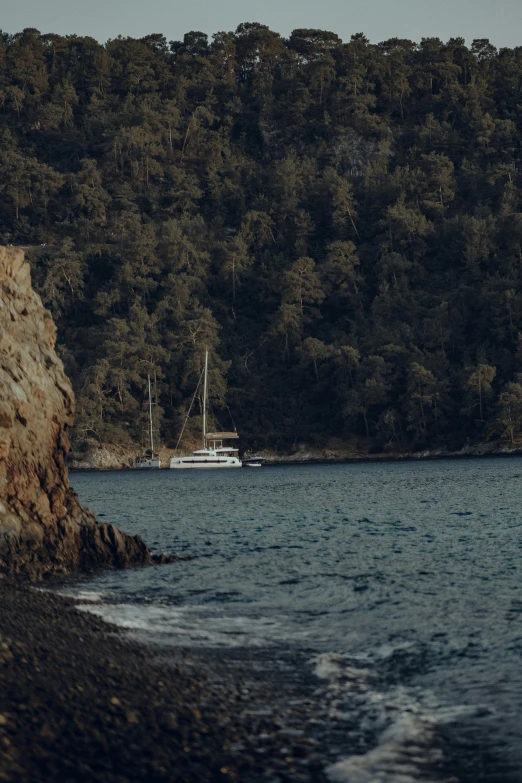 a boat sits on the water next to a shore