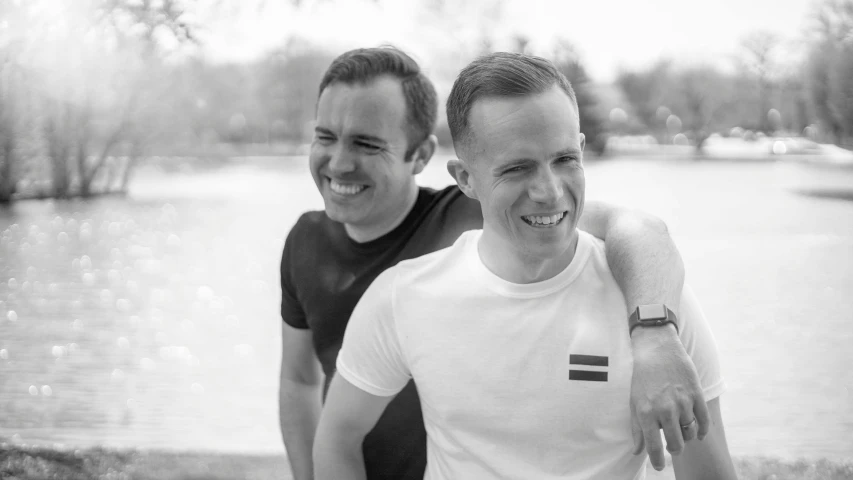 two men are standing close by the water