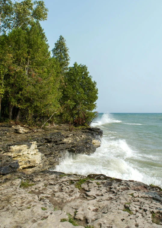 a view of a beach that has some water splashing in the ocean