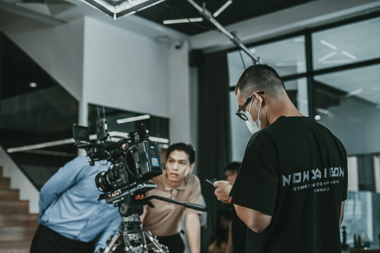 man with black shirt and protective face mask working on camera