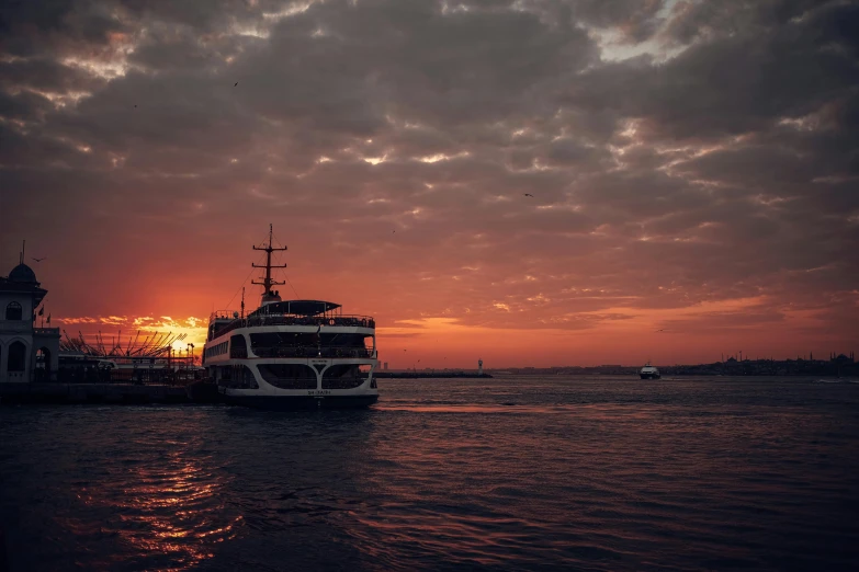 a ferry boat at sunset near a lighthouse