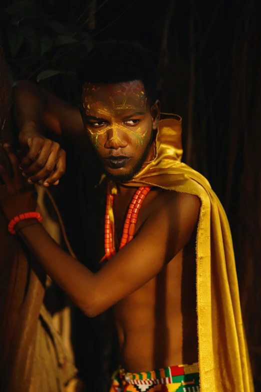 a shirtless man with holi paint on his face and a scarf