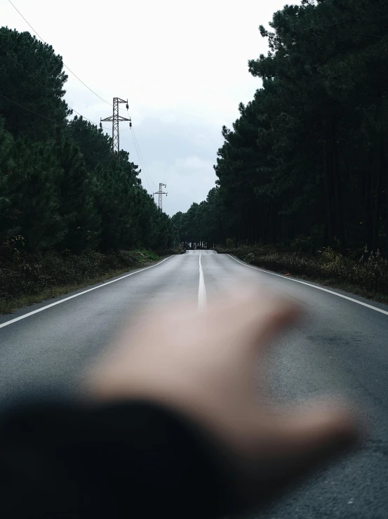 a person holding a camera out on the road