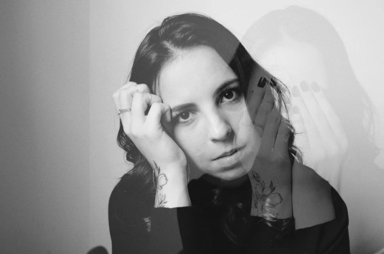 black and white pograph of woman holding her hands behind her head