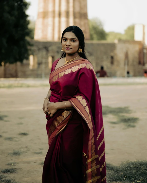 a woman wearing a red and gold indian dress