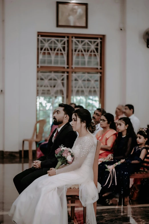 bride and groom seated on the church pew
