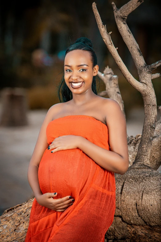 a woman wearing an orange dress smiling and posing for a picture