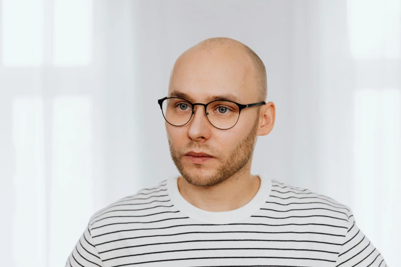 man with bald head looking towards camera