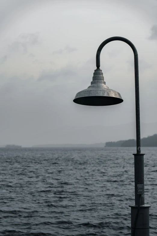 an outdoor lamp is on the side of a beach