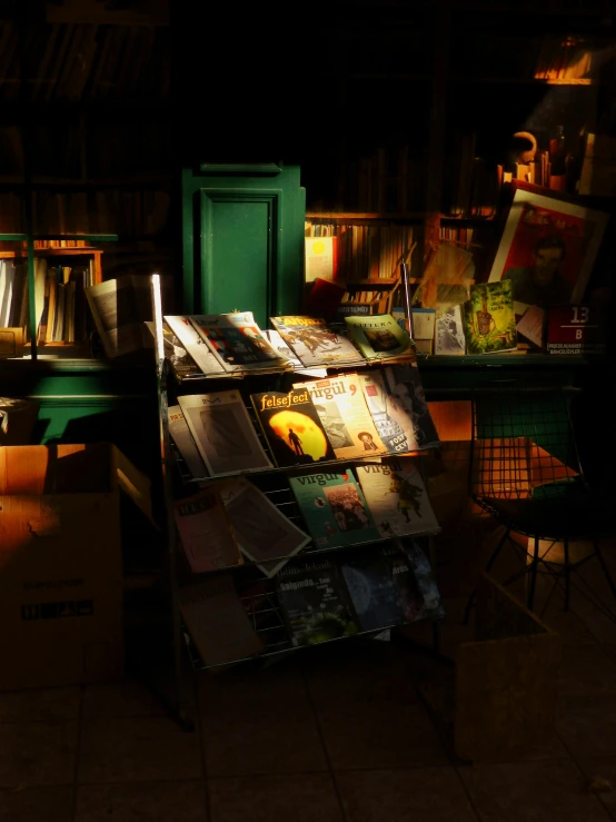 a wooden table holding magazines next to a green cabinet with open doors