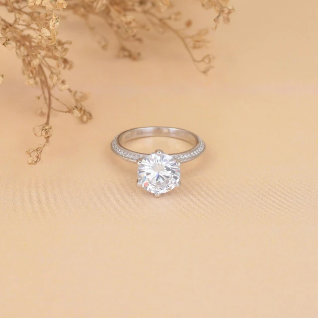 a ring sitting on top of a table next to some flowers