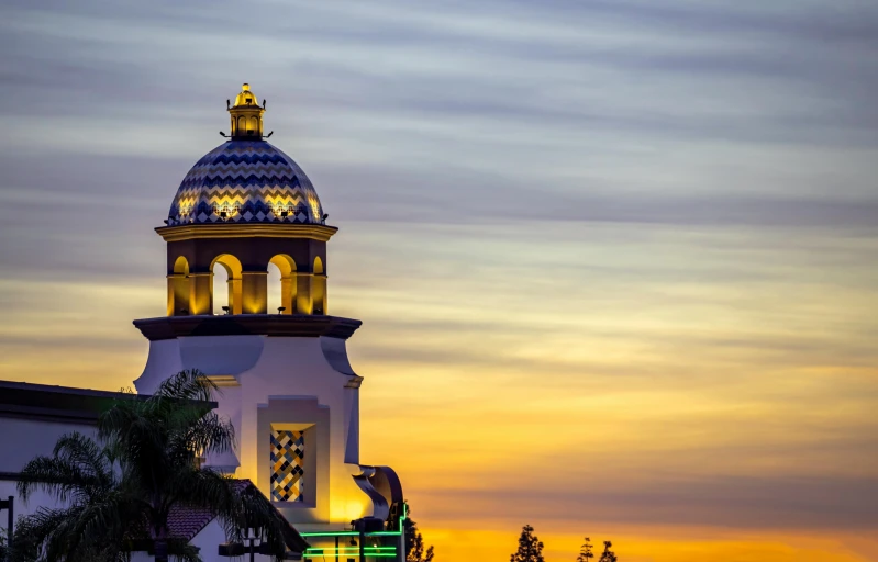 an illuminated clock tower over the city at dusk