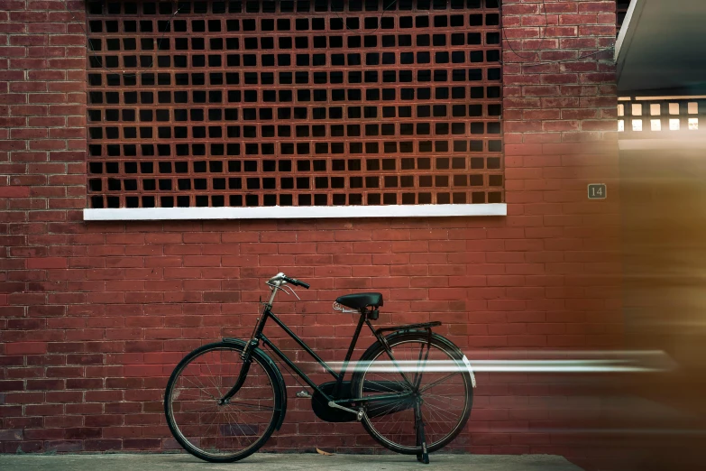 a bicycle parked on the street next to a brick wall