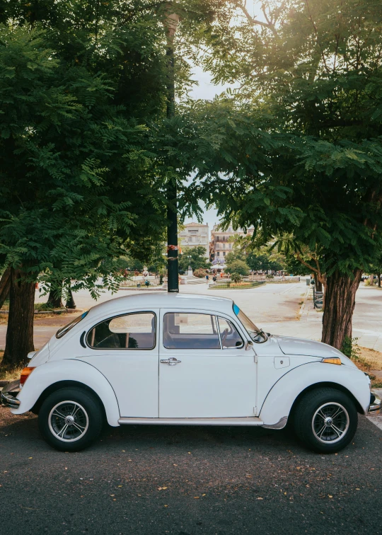 an old white car sits parked in a spot