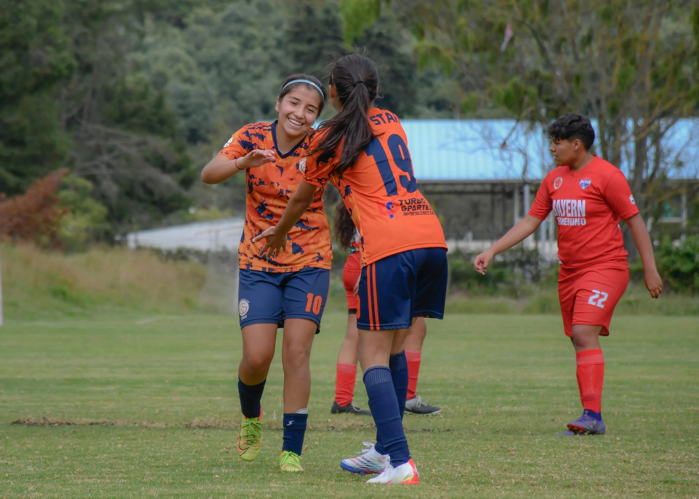 a women's soccer game with a female player celeting