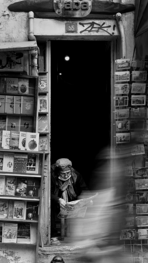 there is a man in a doorway reading a book