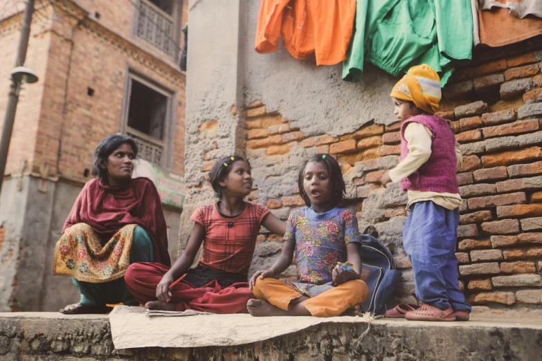 three women and a baby are in a slum village
