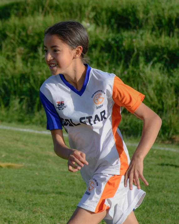a young lady kicking the ball during a soccer game