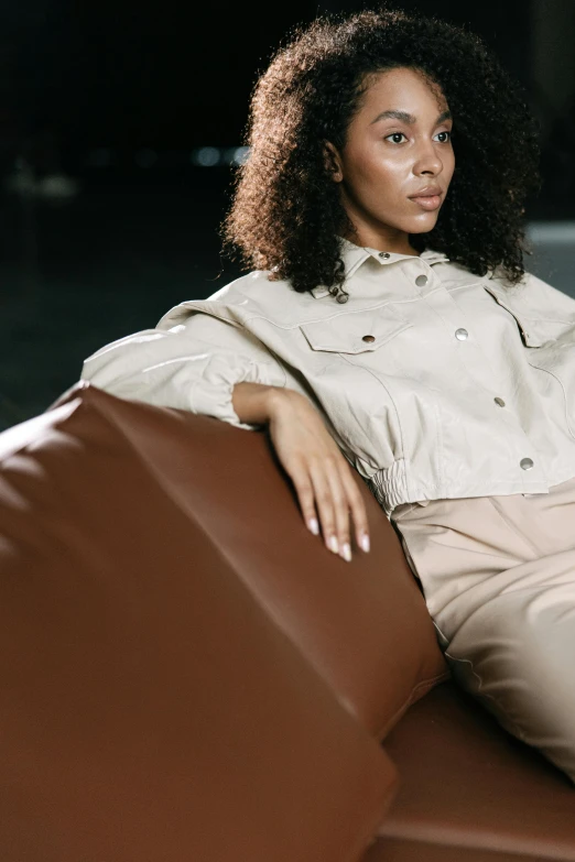 woman sitting in chair with white top and coat on