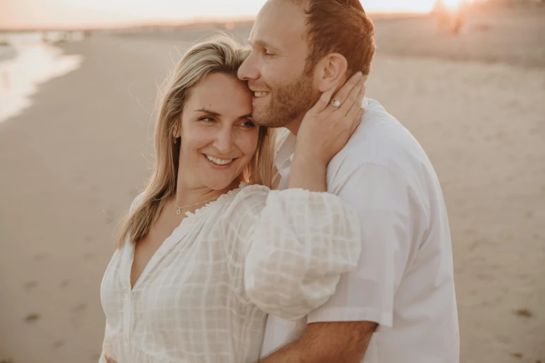 a man hugging a woman at the beach on a sunny day