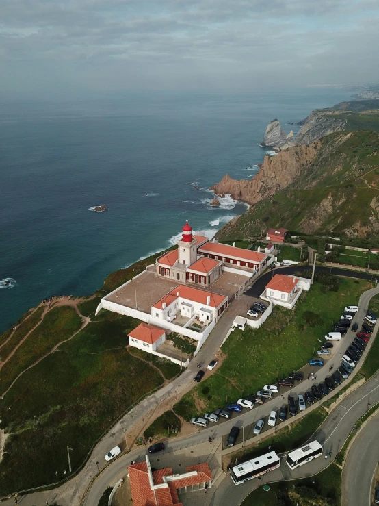 a road near the sea with several vehicles parked next to it