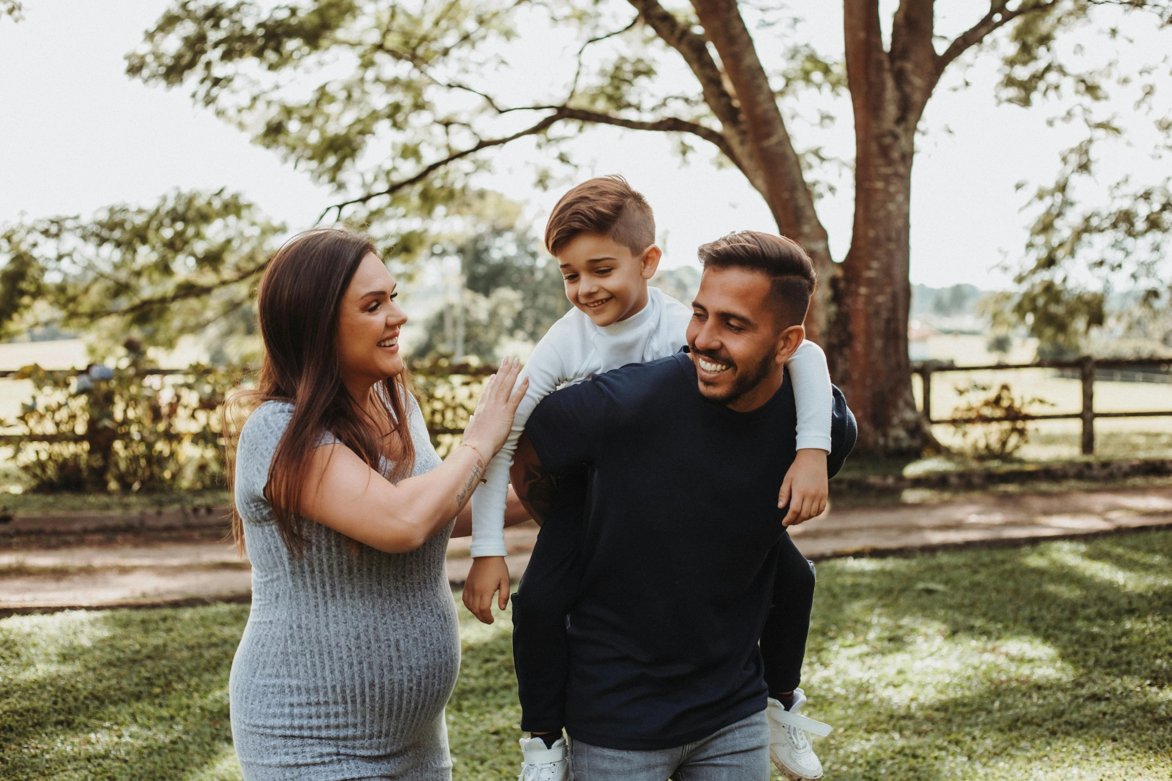 the woman is smiling as her husband holds up his son to him while he is holding the