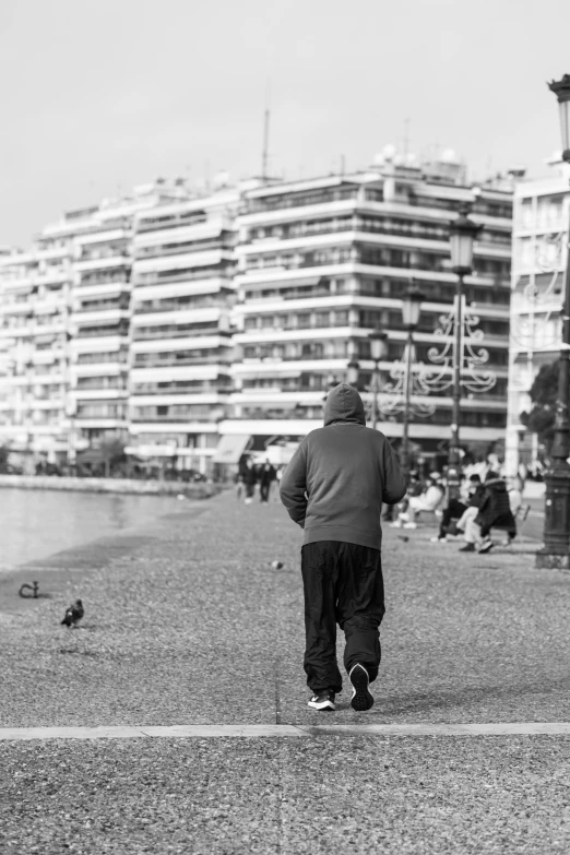 black and white pograph of man walking down the beach