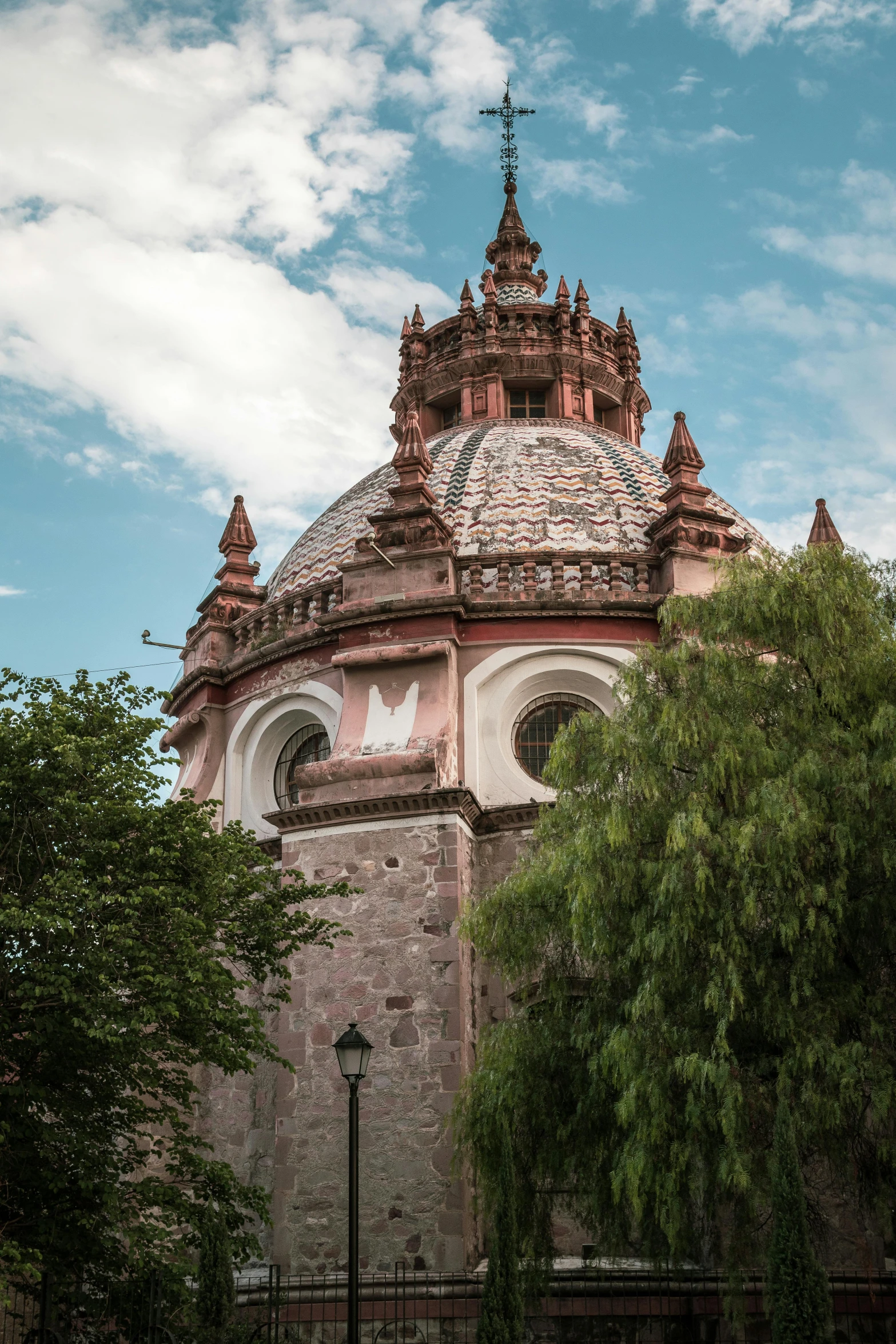 an old stone church with several spires near trees