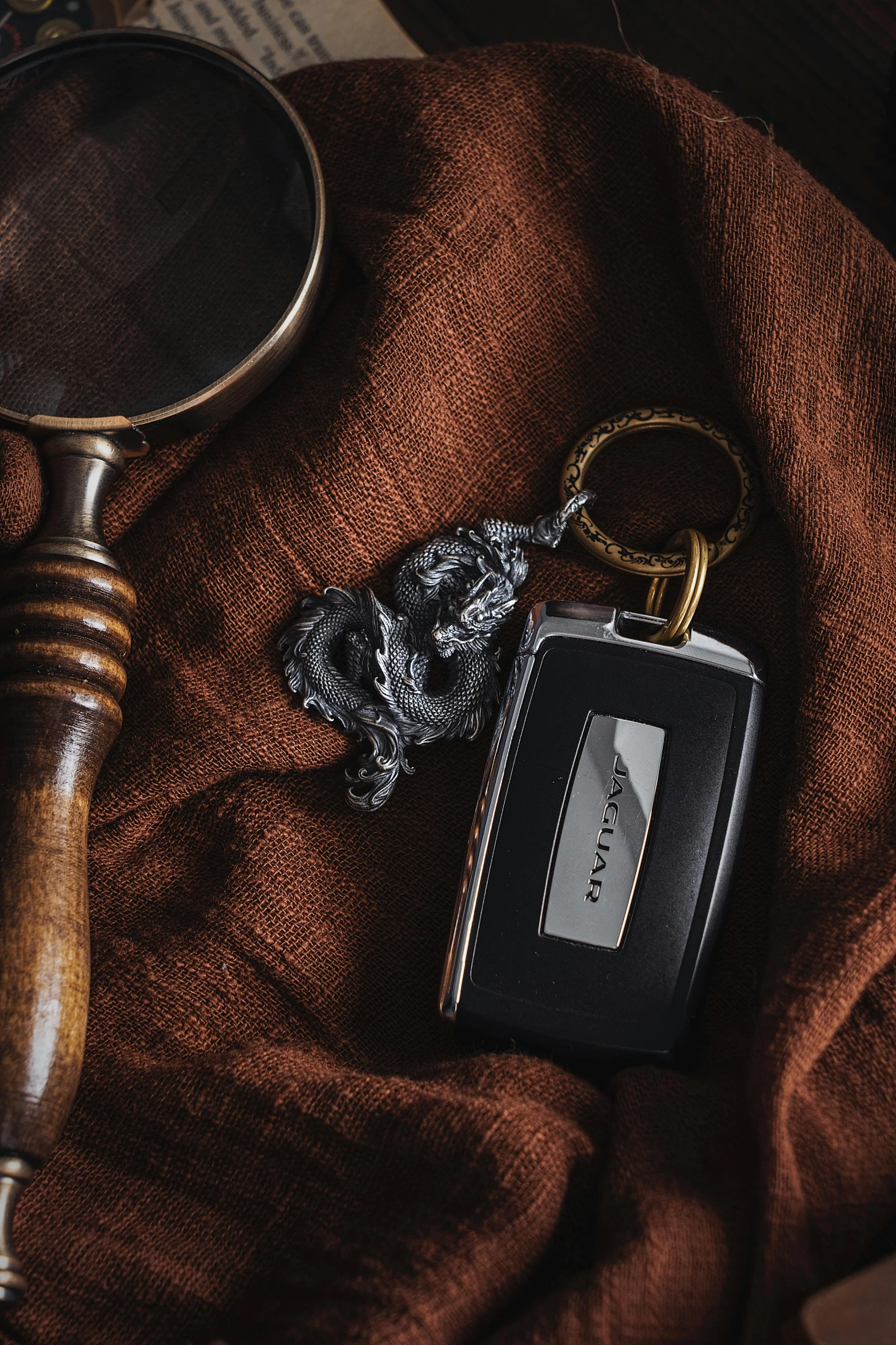 a key ring on top of a wallet next to a magnifying glass