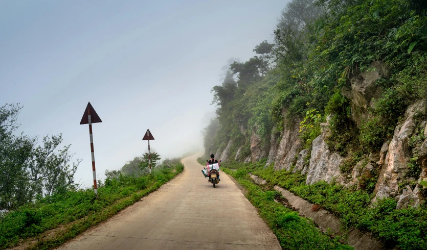 a person riding a motorcycle down a dirt road