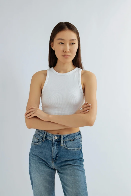 a woman with her arms crossed wearing jeans