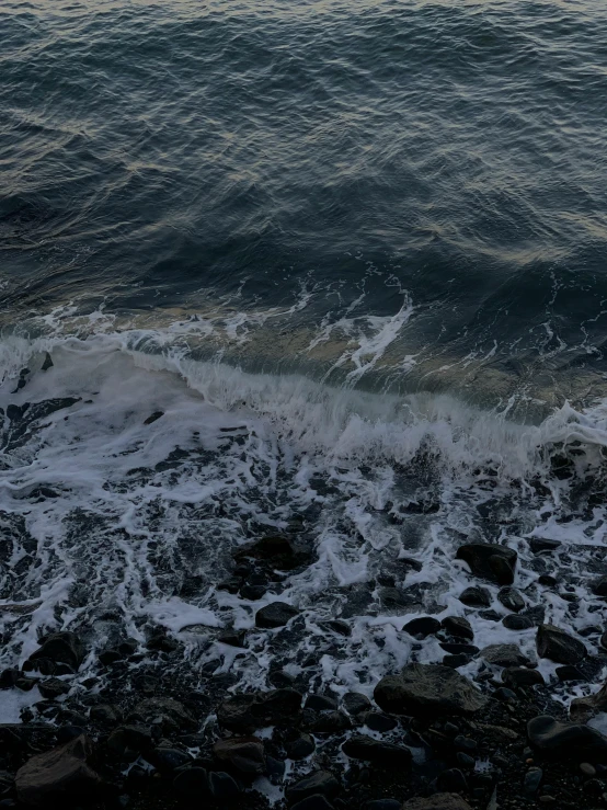 the ocean with waves crashing on rocks and shore